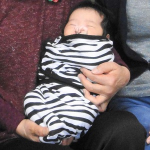 スワドルミーで包まれて抱っこされる赤ちゃんの写真