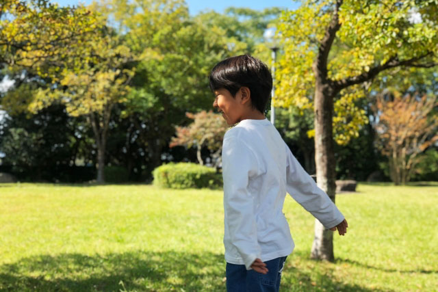 公園で遊ぶ長袖シャツの男の子の写真